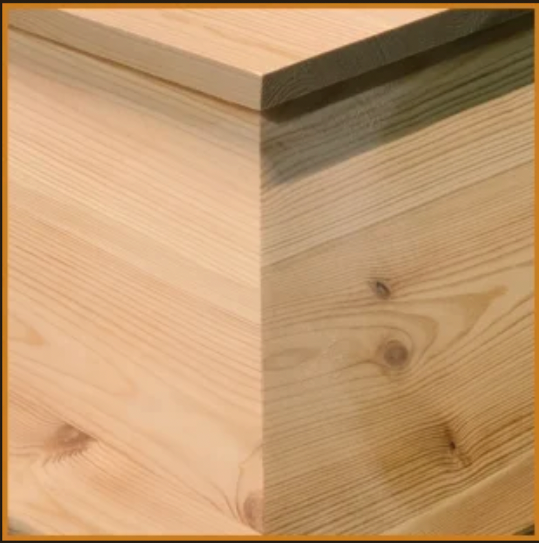 Zoom sur les moulures de l'angle d'un cercueil. Finition lisse. 